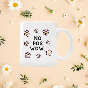 May include: White ceramic mug with a black and white graphic that says "NO POS WOW." The graphic is surrounded by pink and yellow flowers.