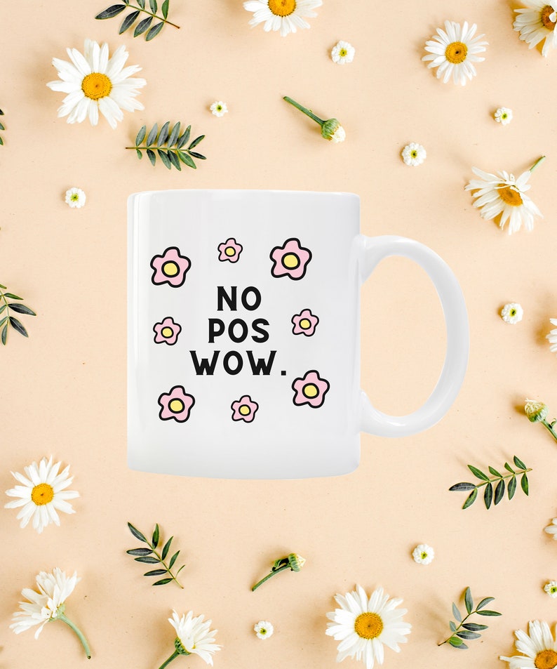 May include: White ceramic mug with a black and white graphic that says "NO POS WOW." The graphic is surrounded by pink and yellow flowers.