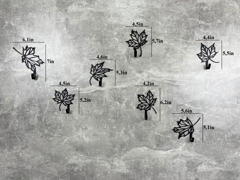 May include: Six black metal leaf-shaped hooks with measurements in inches. The hooks are designed to look like maple leaves.