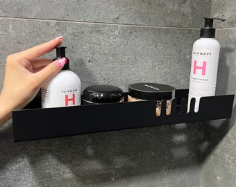 Puede incluir: Estante de metal negro con tres botellas de productos para el cuidado del cabello. Las botellas son blancas con una "H" roja y el texto "Hairwave Professional". Una botella está etiquetada como "Conditioner No Color".