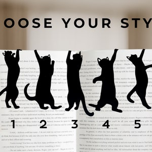 Pu&ograve; includere: Cinque fermacarte in metallo a forma di gatto nero in diverse pose. I fermacarte sono posizionati su un libro con i numeri 1, 2, 3, 4 e 5 visibili sulle pagine.