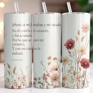 Könnte beinhalten: Drei weiße isolierte Becher mit floralen und botanischen Designs. Die Becher haben einen Strohhalm und zeigen Text auf Spanisch. Das florale Design umfasst rosa, cremefarbene und braune Blumen und Blätter. Die Becher sind für kalte Getränke konzipiert.