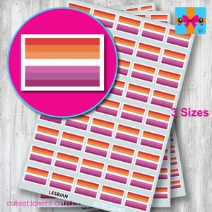 May include: Sheets of stickers featuring the lesbian pride flag in various sizes. The flag design includes horizontal stripes in shades of orange, white, and purple. A large sticker is set in a pink circle. The text "3 Sizes" is visible.