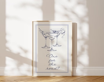 May include: A framed print featuring three cocktail glasses in a blue line drawing. The print has a blue border and the words "One for the road?" in elegant script. The background is a neutral color.