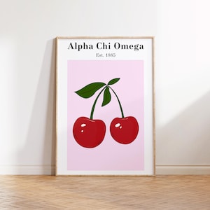 May include: Framed art print featuring a pair of red cherries with green leaves against a pink background. The text "Alpha Chi Omega Est. 1885" is displayed at the top. The print is in a wooden frame.