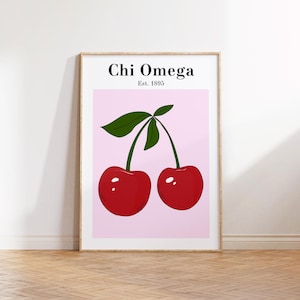 May include: A framed print featuring a pair of red cherries with green leaves against a pink background. The text "Chi Omega Est. 1895" is displayed at the top. The artwork is in a wooden frame.