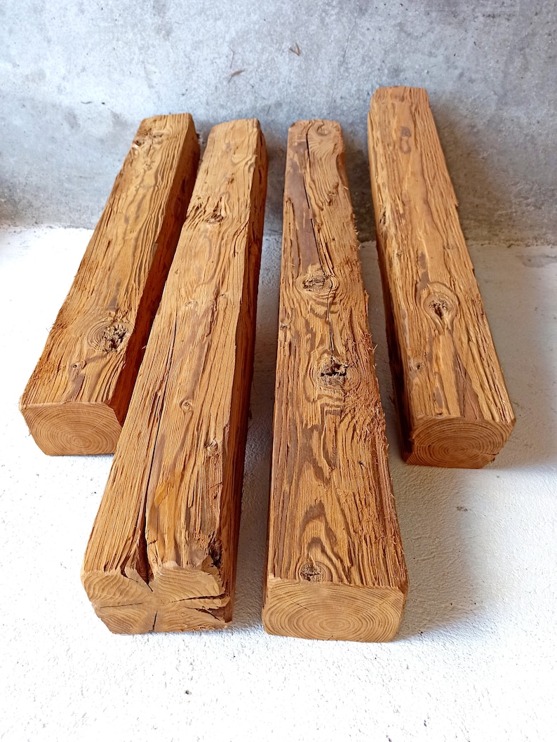 Peut inclure: Quatre poutres en bois de r&eacute;cup&eacute;ration &agrave; l'aspect rustique et vieilli. Les poutres mesurent environ 25 cm de large et 1,2 m&egrave;tre de long. Le bois est de couleur brun naturel avec des n&oelig;uds et des motifs de grain.