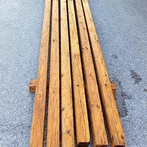 Peut inclure: Une pile de huit poutres en bois de r&eacute;cup&eacute;ration, chacune mesurant environ 3 m&egrave;tres de long et 15 cm de large, avec une couleur brun naturel et une texture rugueuse et patin&eacute;e.