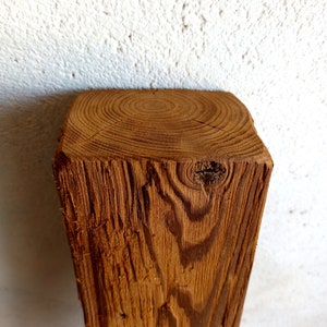 Peut inclure: Gros plan sur une poutre en bois brun brute avec des motifs de grain et des n&oelig;uds visibles.