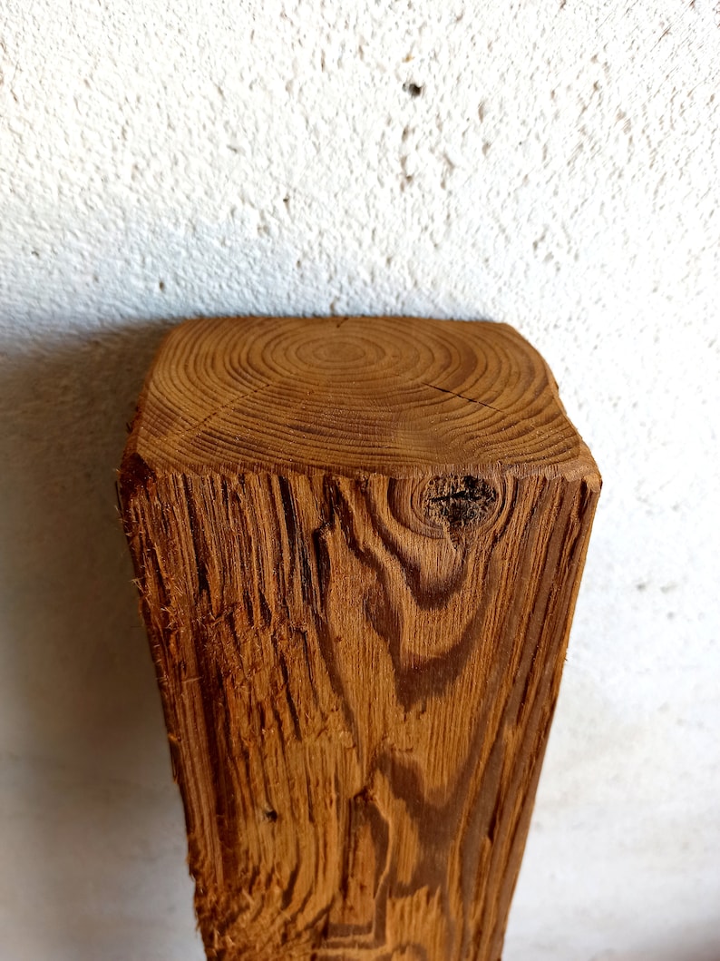 Peut inclure: Gros plan sur une poutre en bois brun brute avec des motifs de grain et des n&oelig;uds visibles.