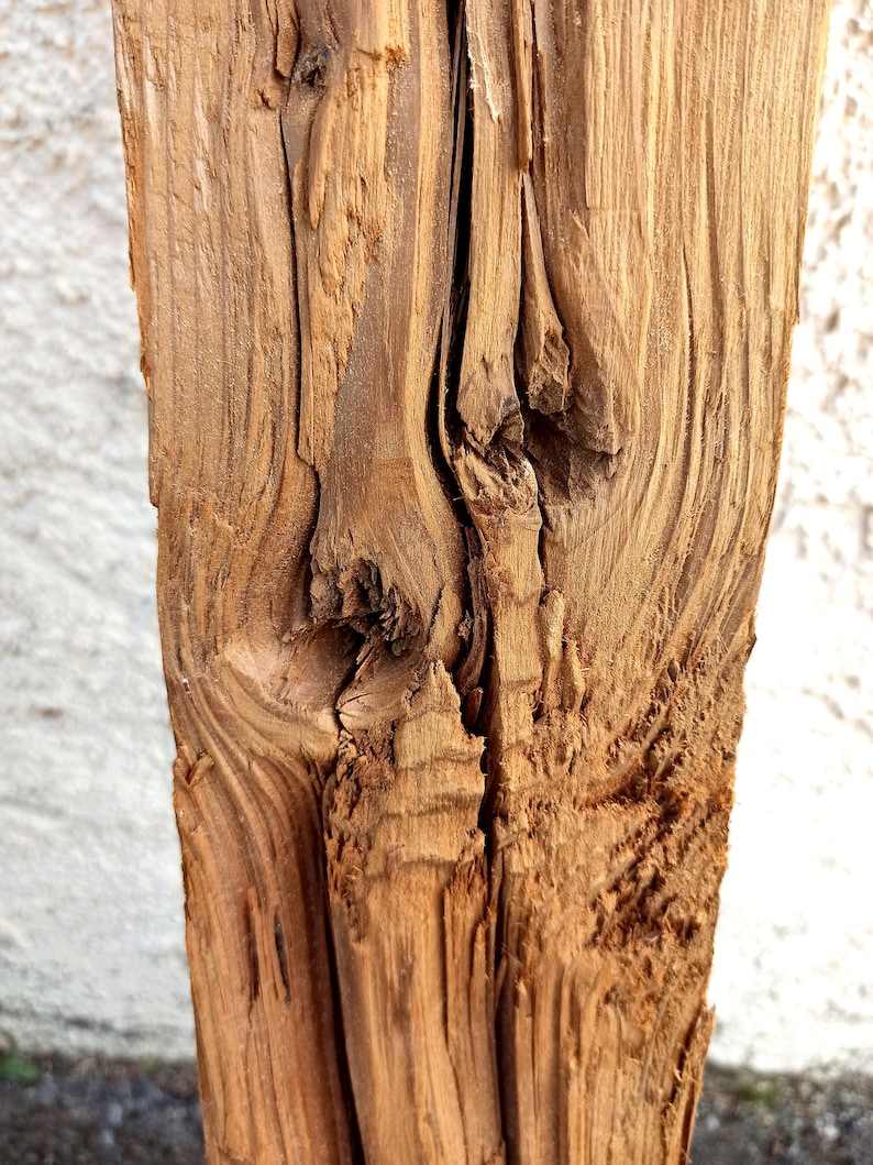 Peut inclure: Gros plan sur une poutre en bois vieillie avec un n&oelig;ud et des motifs de grain. Le bois est de couleur brun clair et a une texture rugueuse.