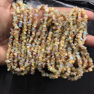 May include: A white ceramic mug with a black handle and the text "But First, Coffee" in a handwritten style. The mug is on a white surface. The mug is 10 cm tall.