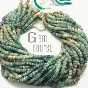 May include: A strand of turquoise blue and cream colored gemstone beads. The beads are small and square shaped. The strand is approximately 18 inches long. Gem Bourse is printed on a white label.