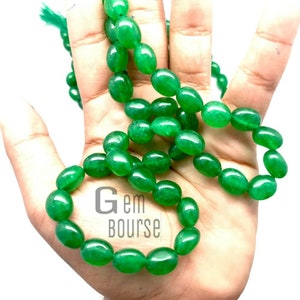 Peut inclure: Un long collier de perles de jade vert. Les perles sont de forme ovale et ont une finition lisse et polie.