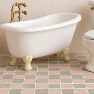 Könnte beinhalten: Ein Miniatur-Badezimmer-Set mit einer weißen Badewanne mit Löwenfüßen, einer Toilette und einem Holzwaschtisch mit Spiegel. Die Badewanne hat verzierte Füße und einen Wasserhahn aus Messing. Der Boden ist gefliest.