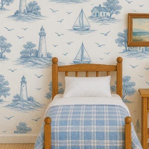May include: Miniature bedroom scene with a wooden bed, nightstand, and lamp. The bed has a blue plaid blanket and white pillow. The wallpaper features a blue and white nautical design with lighthouses, sailboats, and birds. A framed landscape painting hangs on the wall.