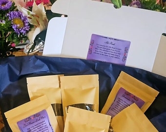 May include: A blue box filled with small brown paper bags containing loose leaf tea. The bags are labeled with different tea names, including "To Hawn Low No. 1" and "Silk Road".