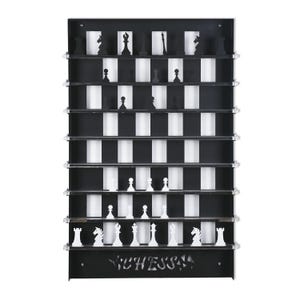 May include: A black wooden chessboard with white squares and black squares. The chessboard is mounted on a wall and has a shelf for each row of the board. The chess pieces are black and white and are arranged on the board in a starting position. The word "CHESS" is cut out of the bottom of the board.