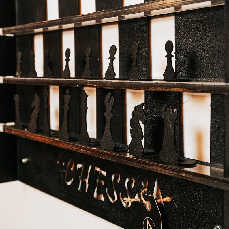 May include: A wooden chessboard with black and white squares. The board is filled with black chess pieces, including pawns, rooks, knights, bishops, a queen, and a king. The board is labeled "Chess" at the bottom.