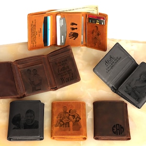 May include: Six different leather wallets with various personalized engravings and photos. The wallets are brown, black, and dark brown. Some of the engravings include "Dad, A very big love, A daughter's love", "To the world you are a Father, but to our family you are the World", and "EAM".