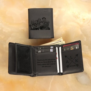 May include: Black leather trifold wallet with a personalized message and a photo of a family engraved on the front. The message reads "Thank you for everything that you have done for us! Keep smiling and singing!! We love you!" and the initials "LAK" with a date.