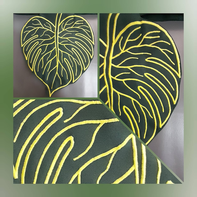 May include: A dark green fabric leaf-shaped item featuring raised, bright yellow embroidered lines that mimic the veins of a monstera leaf. The design is shown in a full view and two close-up perspectives, highlighting the textured stitching.