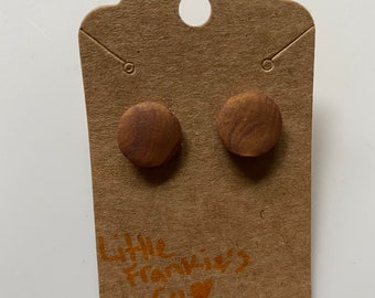 May include: A pair of brown stud earrings with a wood grain pattern on a brown card with the text "Little Frankies Co."