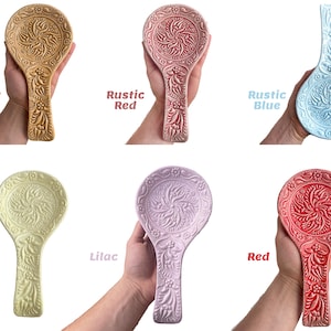 Pode incluir: Seis repousas de colher de cer&acirc;mica em v&aacute;rias cores, incluindo marrom cobre, vermelho r&uacute;stico, azul r&uacute;stico, amarelo lim&atilde;o, lil&aacute;s e vermelho. Cada repousa de colher apresenta um design floral intrincado.