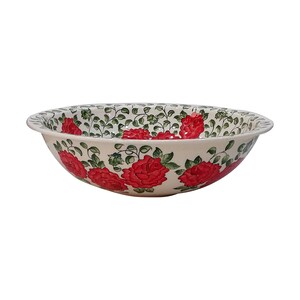 May include: A white ceramic bowl with a floral design. The bowl is decorated with red roses and green leaves.