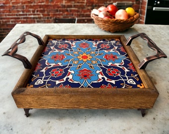 May include: A wooden serving tray with ornate tile inlay featuring blue, red, and white floral patterns. The tray has two metal handles and four feet.