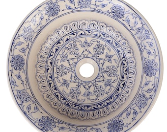 May include: A round, off-white ceramic sink basin with a central drain hole. The basin is decorated with intricate blue floral and scrollwork patterns. The design features concentric circles of detailed motifs.