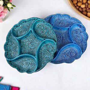 Könnte beinhalten: Zwei Keramik-Servierplatten mit aufwendigen Blumendesigns. Die Platten sind in vier Abschnitte unterteilt und in den Farben Türkis und Blau gehalten.