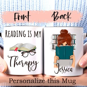 May include: White ceramic mug with a black handle. The front of the mug reads "Reading is my Therapy" with a book and glasses illustration. The back of the mug features a woman with brown hair reading a book in a library setting. The text "Jessica" is printed below the illustration.