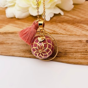 Stainless steel pregnancy bola with gold plated copper bola ball and dried pink resin.
