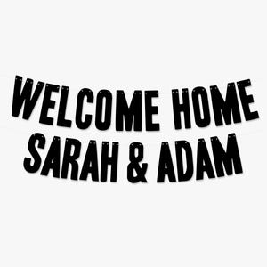 Może przedstawiać: Czarno-biały baner powitalny do domu z tekstem "WELCOME HOME SARAH & ADAM".