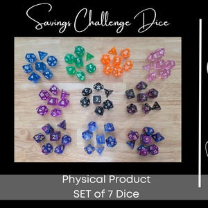 May include: A selection of seven sets of dice in various colours, including blue, green, orange, pink, purple, black, and a mix of blue and purple. The dice are arranged on a wooden surface. Text at the top reads "Savings Challenge Dice".