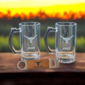May include: Two clear glass beer mugs with a longhorn steer logo and the name "JONES" etched on each. A brown leather bottle opener with the text "HOOK 'EM HORNS" is included.