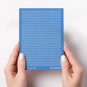 Pode incluir: Uma folha azul com um padrão de chevron branco. A folha tem o texto "Clay parade" e "SC-345876" impresso nela.