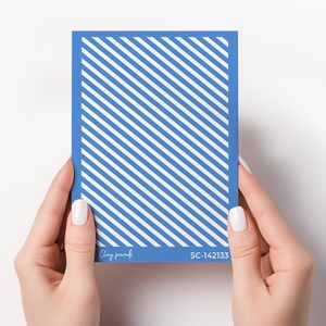May include: A blue card with white diagonal stripes. The card has the text "Clay paradisi" and "SC-142133" printed on it.