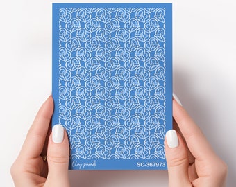 May include: A blue stencil with a repeating white pretzel pattern. The stencil is held by two hands with white nail polish. The text "Clay parade" and "SC-367973" are printed on the stencil.