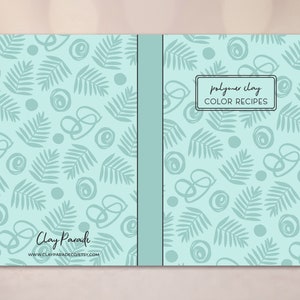 May include: A teal blue notebook with a leafy pattern and the text "polymer clay COLOR RECIPES" on the front cover. The back cover has the text "Clay Parade" and a website address.