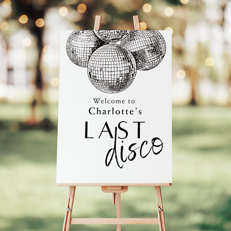 May include: White sign with black text and illustrations of disco balls. The text reads "Welcome to Charlotte's Last Disco".