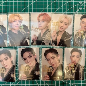 May include: Eight photo cards featuring a group of men in black and gold outfits. The men are holding birthday props and smiling. The cards are in plastic sleeves.