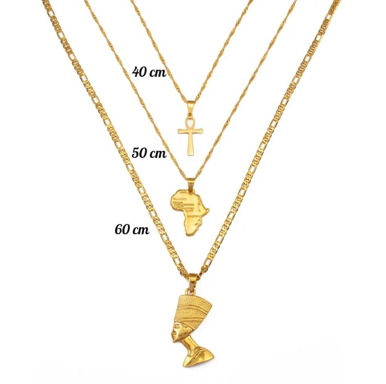 May include: Three gold-colored necklaces of varying lengths, each with a unique pendant. The shortest necklace is 40 cm long and has an Ankh pendant. The middle necklace is 50 cm long and features an Africa-shaped pendant. The longest necklace is 60 cm and has a Nefertiti pendant.