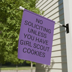 May include: Purple flag with the text "NO SOLICITING UNLESS YOU HAVE GIRL SCOUT COOKIES" printed in black.