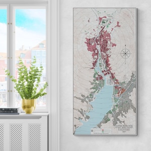 Puede incluir: Un mapa enmarcado de Nagasaki, Japón, que representa los daños de la bomba atómica. El mapa utiliza un sistema codificado por colores para mostrar la extensión de la destrucción. Una rosa de los vientos está en la esquina superior derecha. El texto "U.S. Strategic Bombing Survey ATOMIC BOMB DAMAGE NAGASAKI Japan" está en la parte inferior.