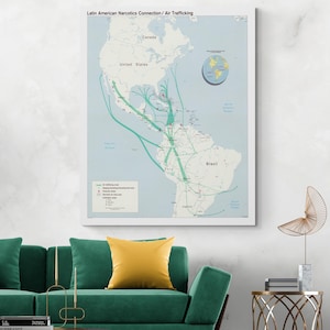 May include: A framed map titled "Latin American Narcotics Connection / Air Trafficking" depicts North and South America with green lines illustrating trafficking routes. The map includes a globe graphic and a legend. The map is displayed above a green sofa with a yellow pillow.