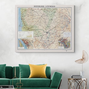 May include: A framed vintage map of Lithuania, featuring detailed road networks and geographical features. The map is in shades of beige, green, and brown, with the text "REPUBLIKA LITEWSKA" at the top. The map is displayed on a white wall above a green sofa.