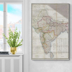 May include: A framed antique map of India, showing detailed cartography with various colours and text. The map is divided into sections and has a grid overlay. The title "INDIA" is visible at the bottom. The map is displayed on a white wall.