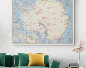 May include: A framed vintage map of Antarctica, showing detailed geographical features and place names. The map has a cream background with blue and pink accents. The title "Antarctica" is displayed at the top. The map is a decorative piece.